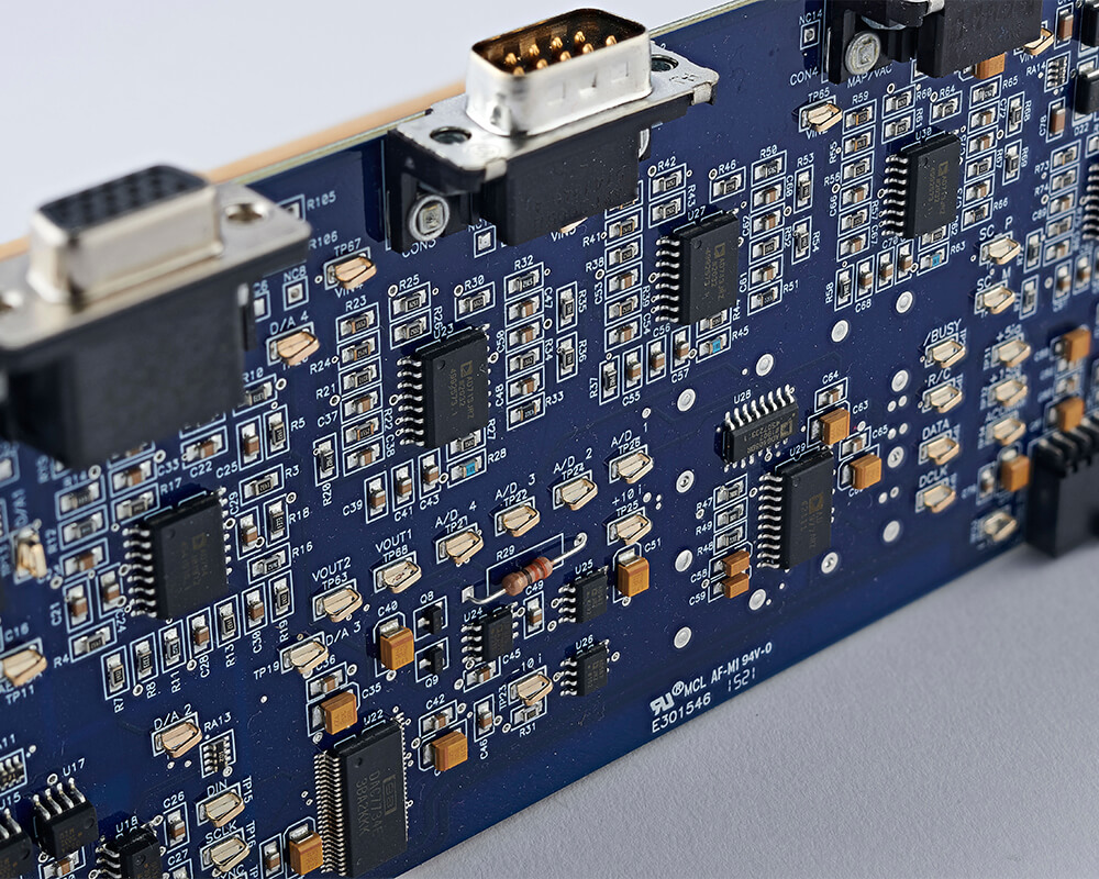 Detailed view of a blue printed circuit board featuring an array of surface-mounted components and integrated circuits.